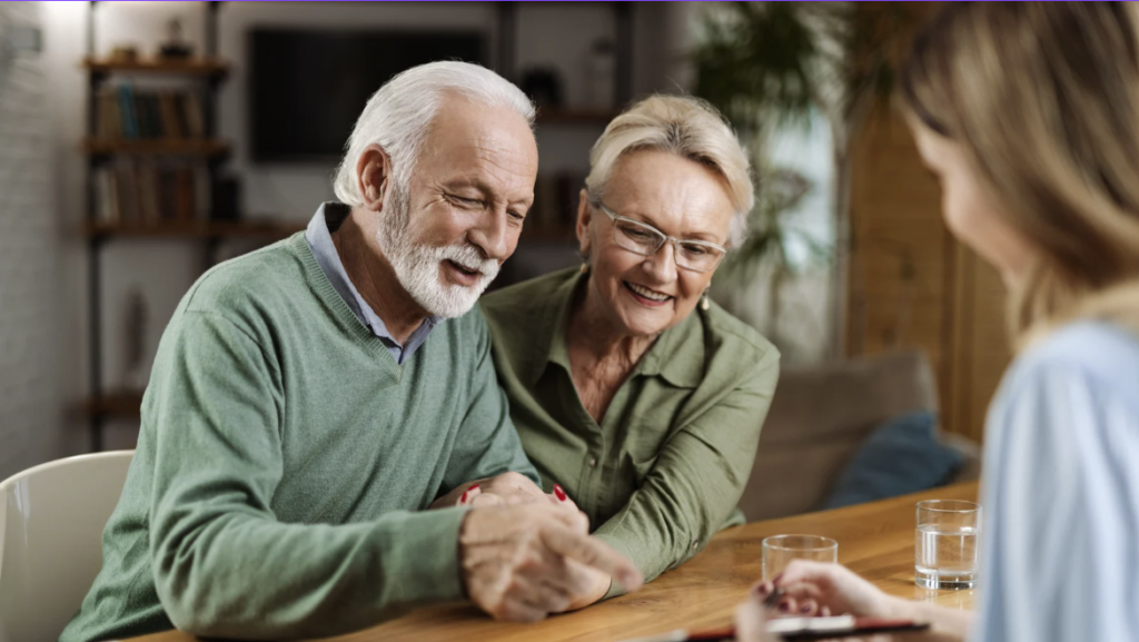 A couple sitting at a table with a tablet.